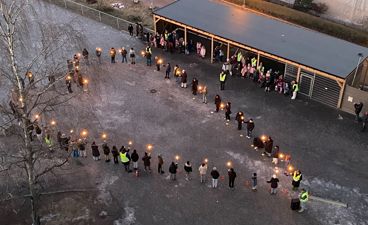 en gruppe mennesker som går på en gate med lys
