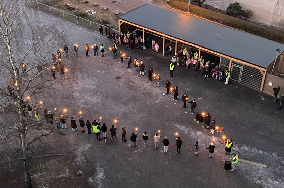 en gruppe mennesker som går på en gate med lys