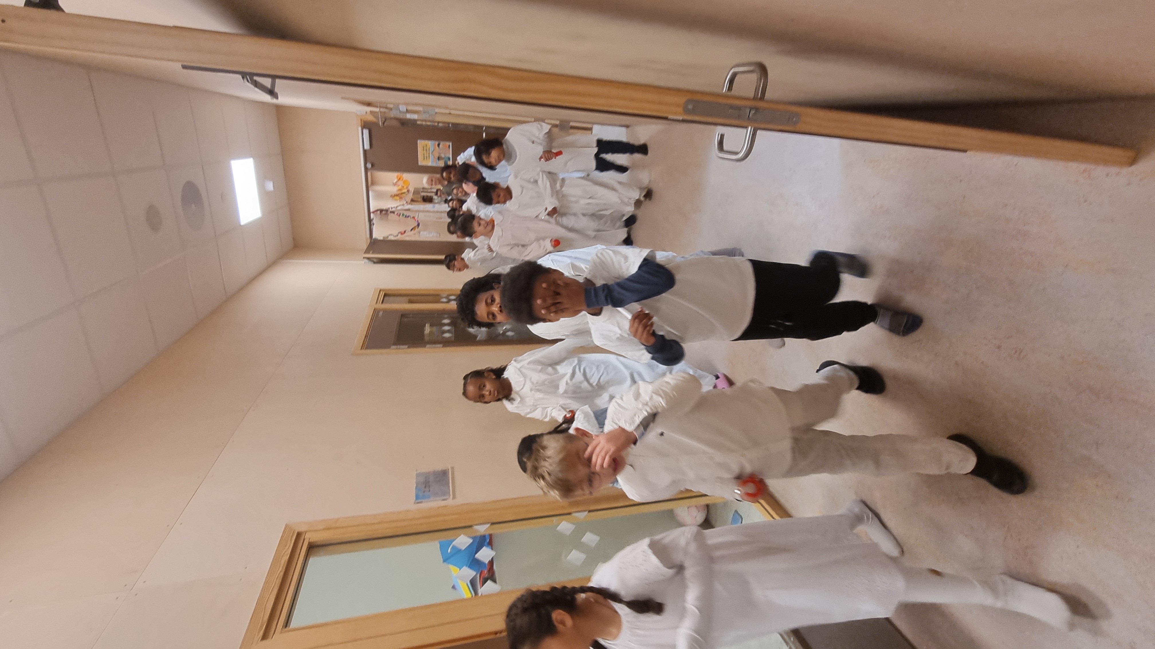 En gruppe mennesker i hvite uniformer løper i en korridor