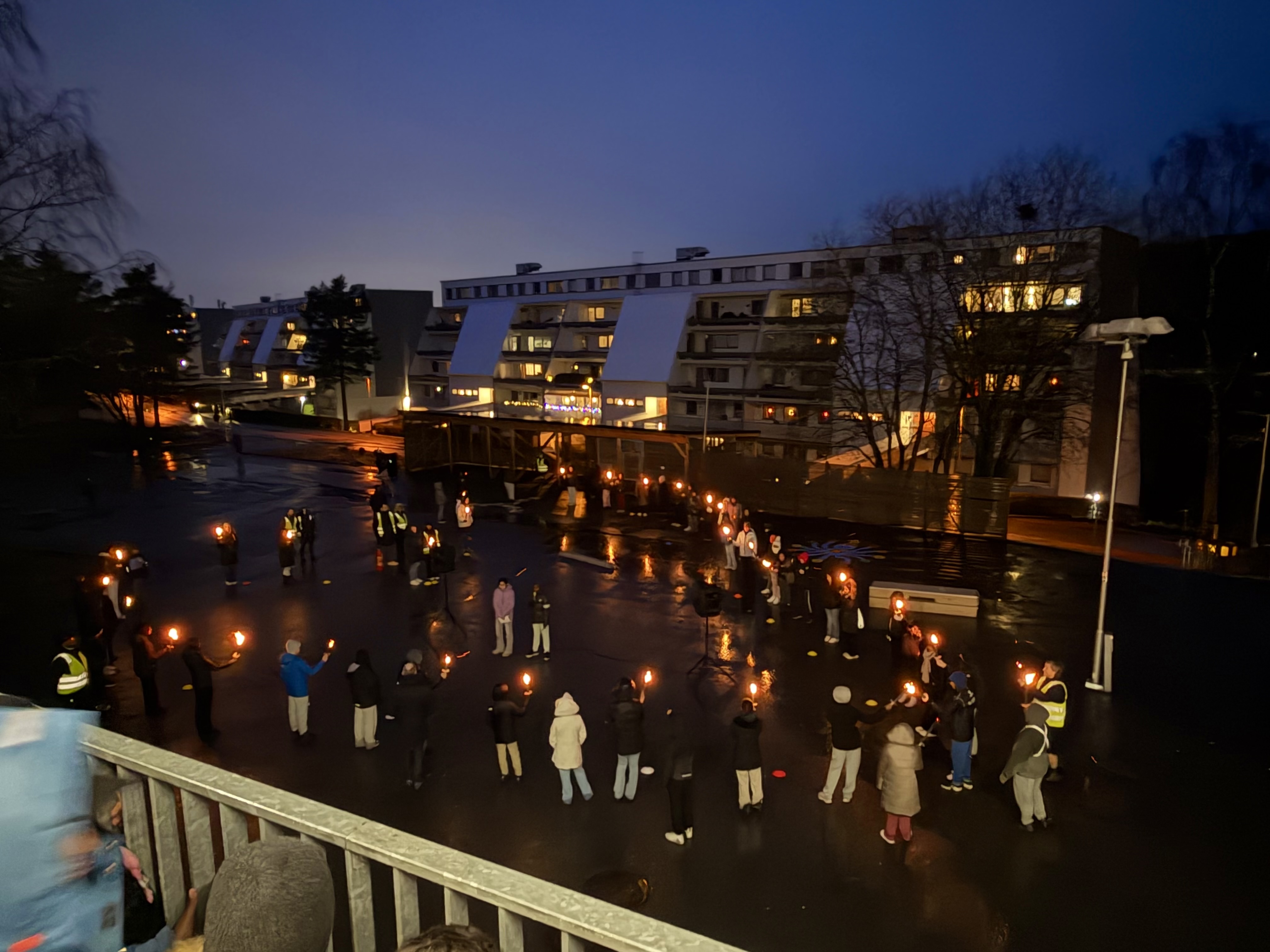 en gruppe mennesker som går på en gate om natten